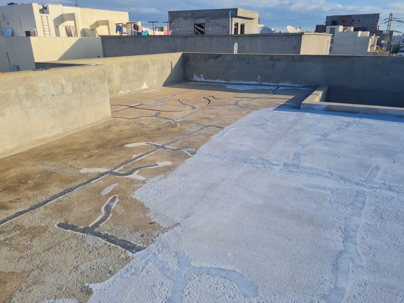 Terrasse en cours d'étanchéité : à gauche le béton fissuré, à droite la membrane ECO-PROOF